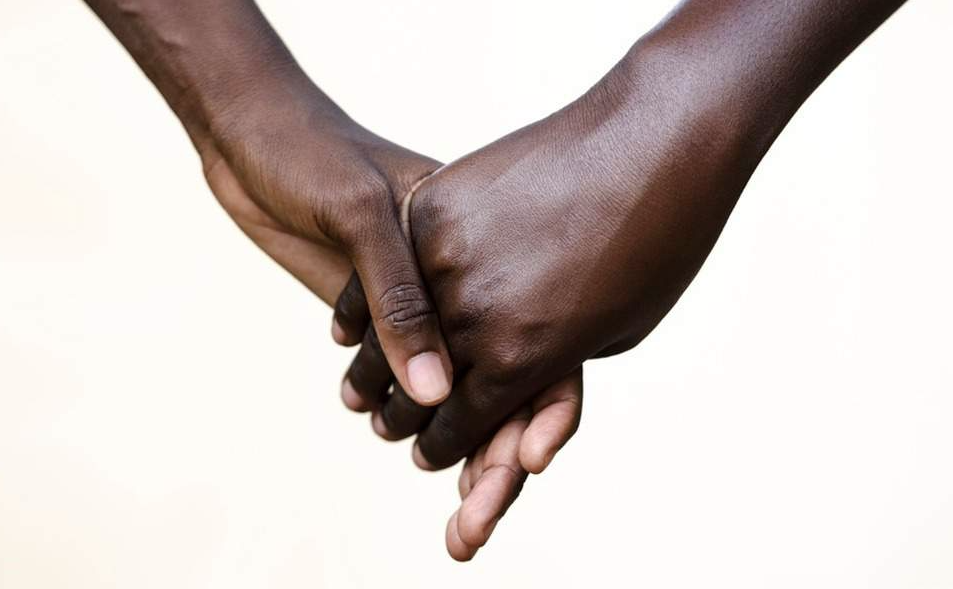Duas pessoas negras dando as mãos